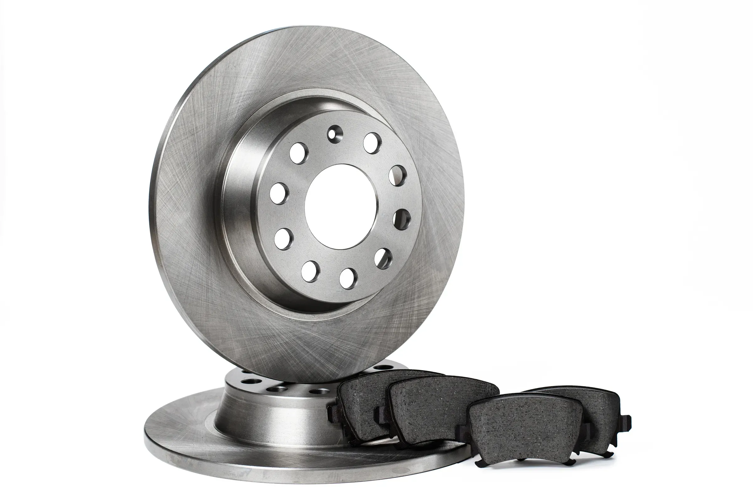 Two new brake discs and a set of brake pads stacked in a row on a white background. isolated items, auto parts ecommerce