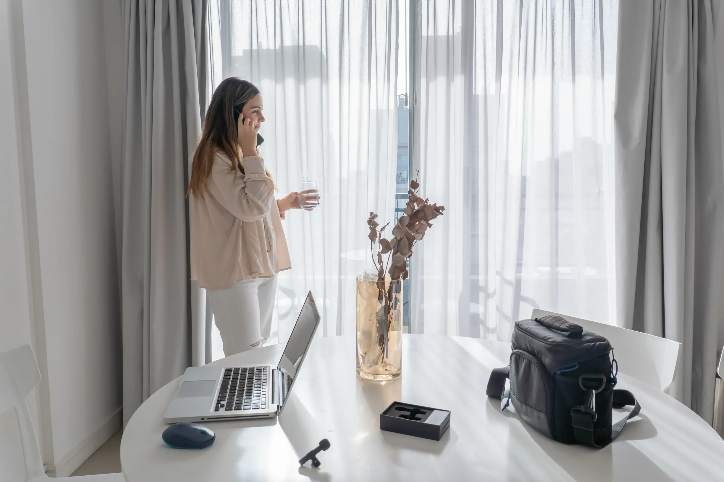 Woman Talking On Phone Call By Window With Camera Gear, camera & drone bags ecommerce