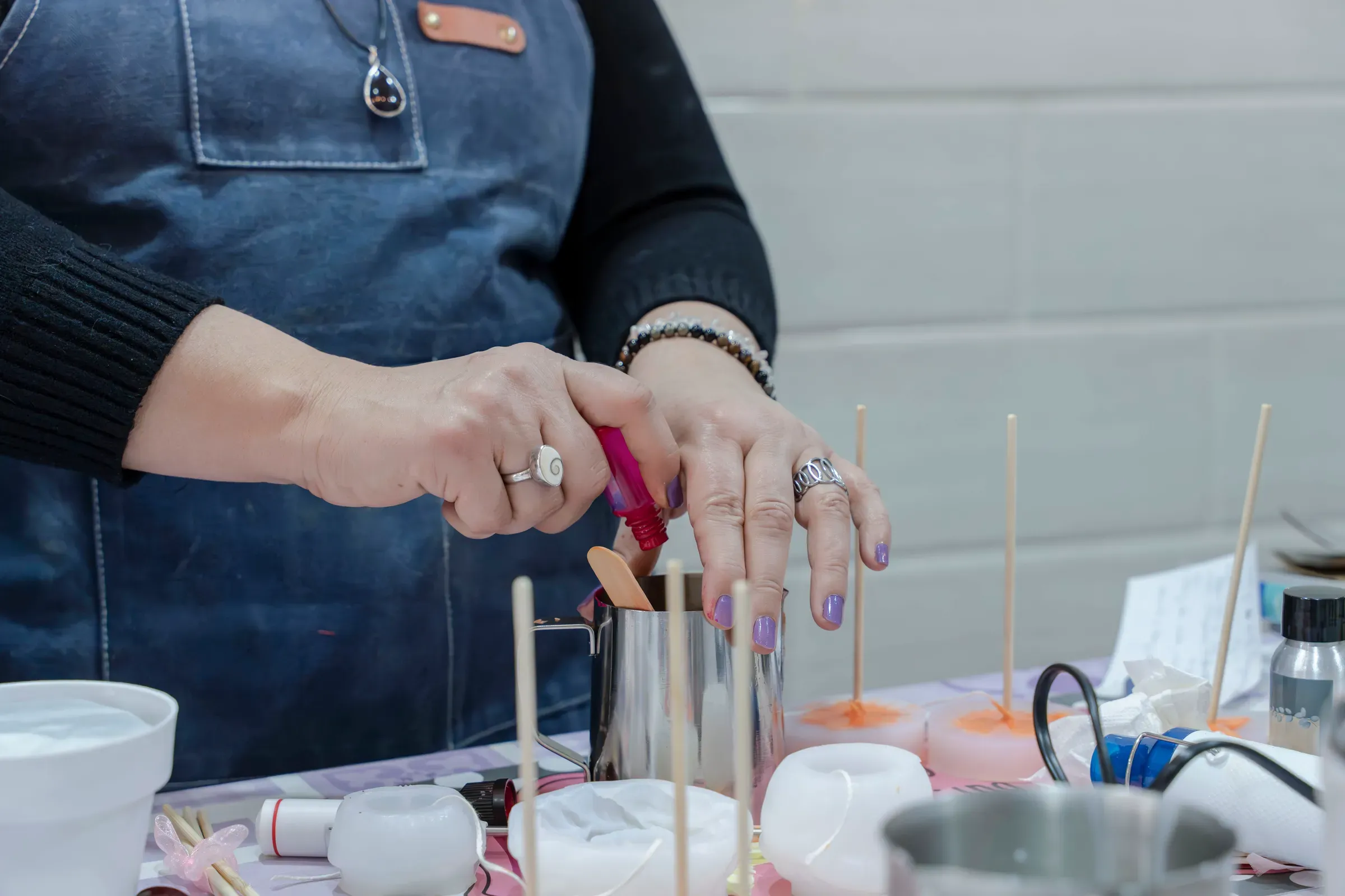 Woman pouring dye into wax making handmade candles, candle & soap making supplies ecommerce