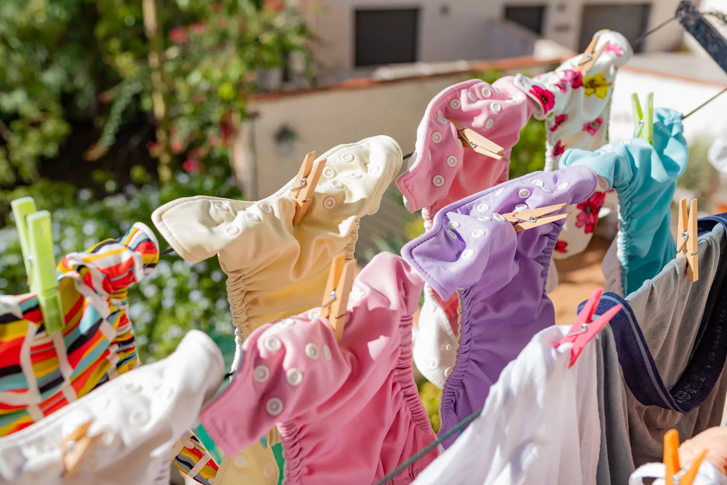 Cloth diapers hanging while drying under the sun on clothesline. Laundry of colorful reusable nappies for, cloth diapers & eco baby ecommerce