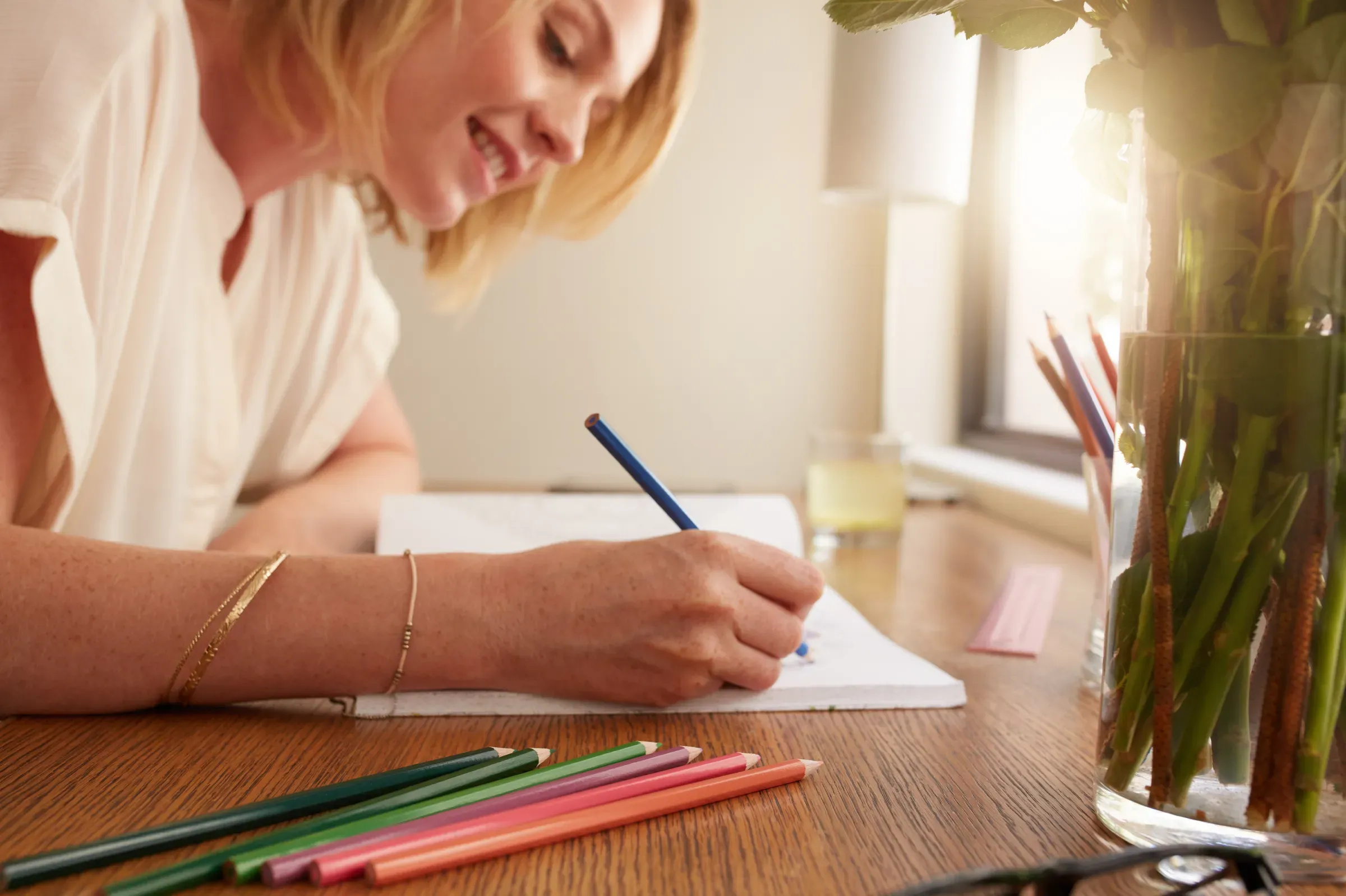 Woman coloring an adult coloring book with pencils, coloring & activity books ecommerce