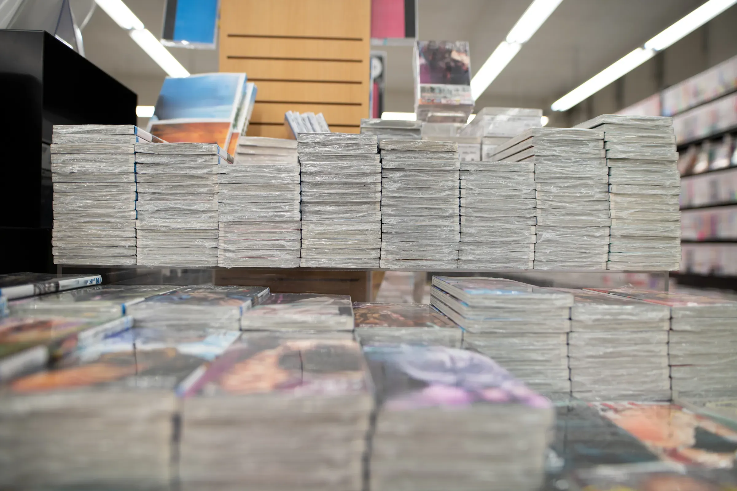 Many manga books stacked in a bookstore, comics & manga ecommerce