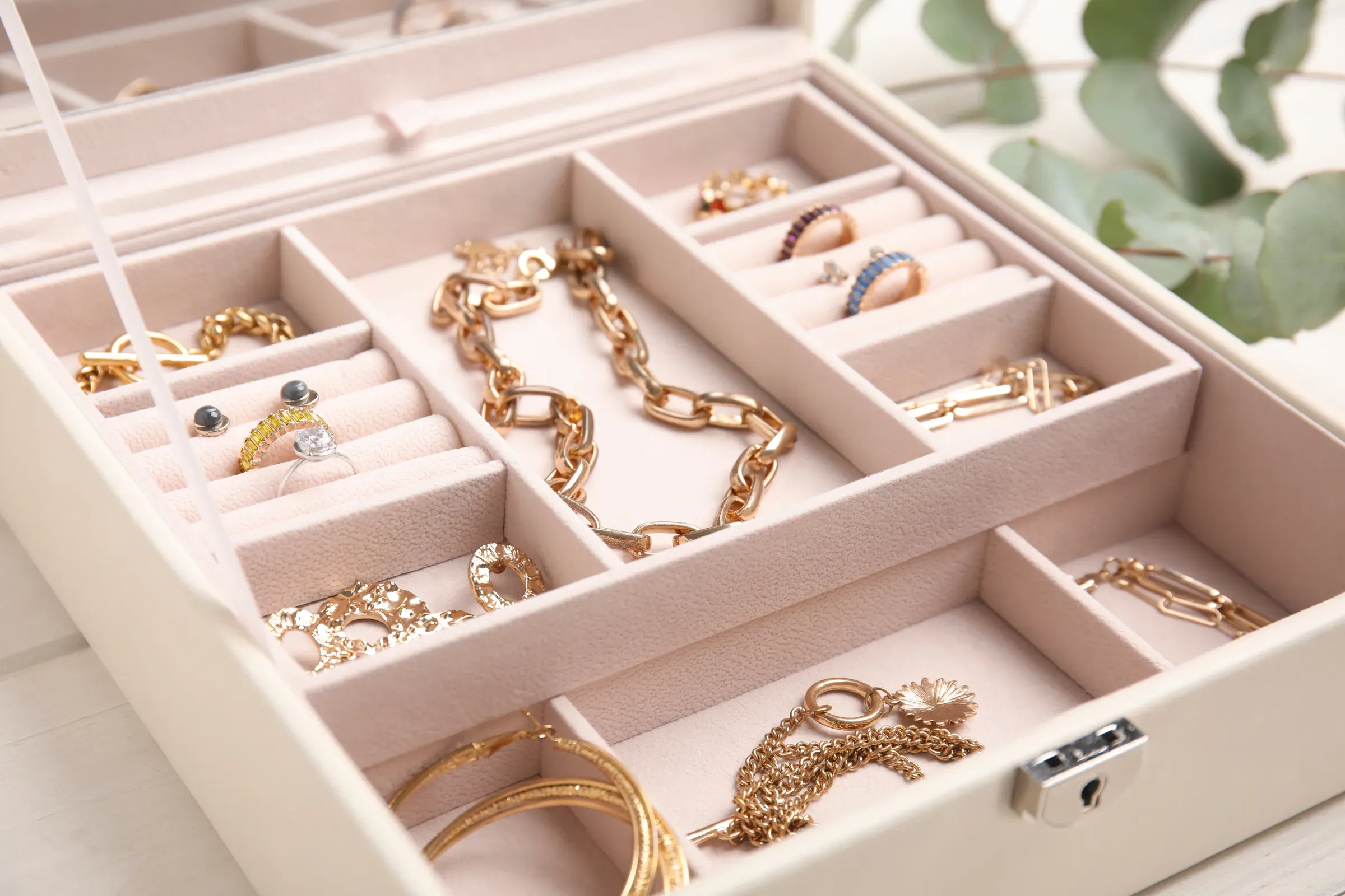 Jewelry box with stylish golden bijouterie on white wooden table, closeup, fine jewelry ecommerce