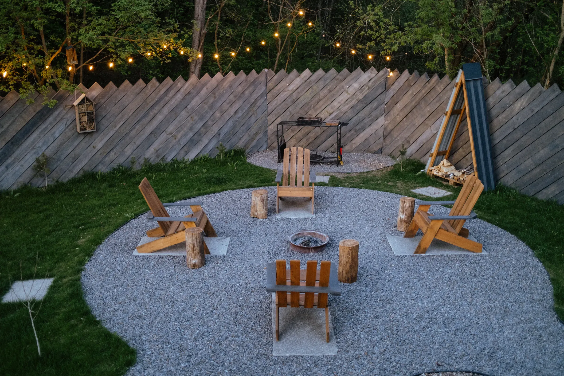 Cozy backyard fire pit area with wooden chairs, string lights, evening gathering, fire pits & heaters ecommerce