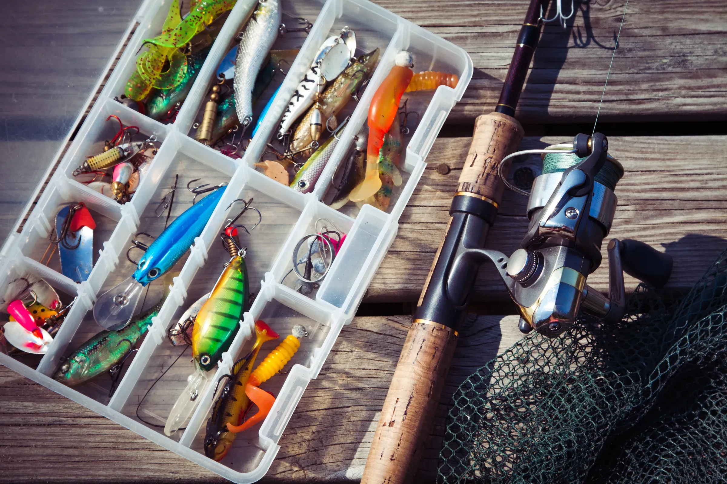 Fishing Lures in tackle boxes with spinning rod and net, fishing tackle ecommerce