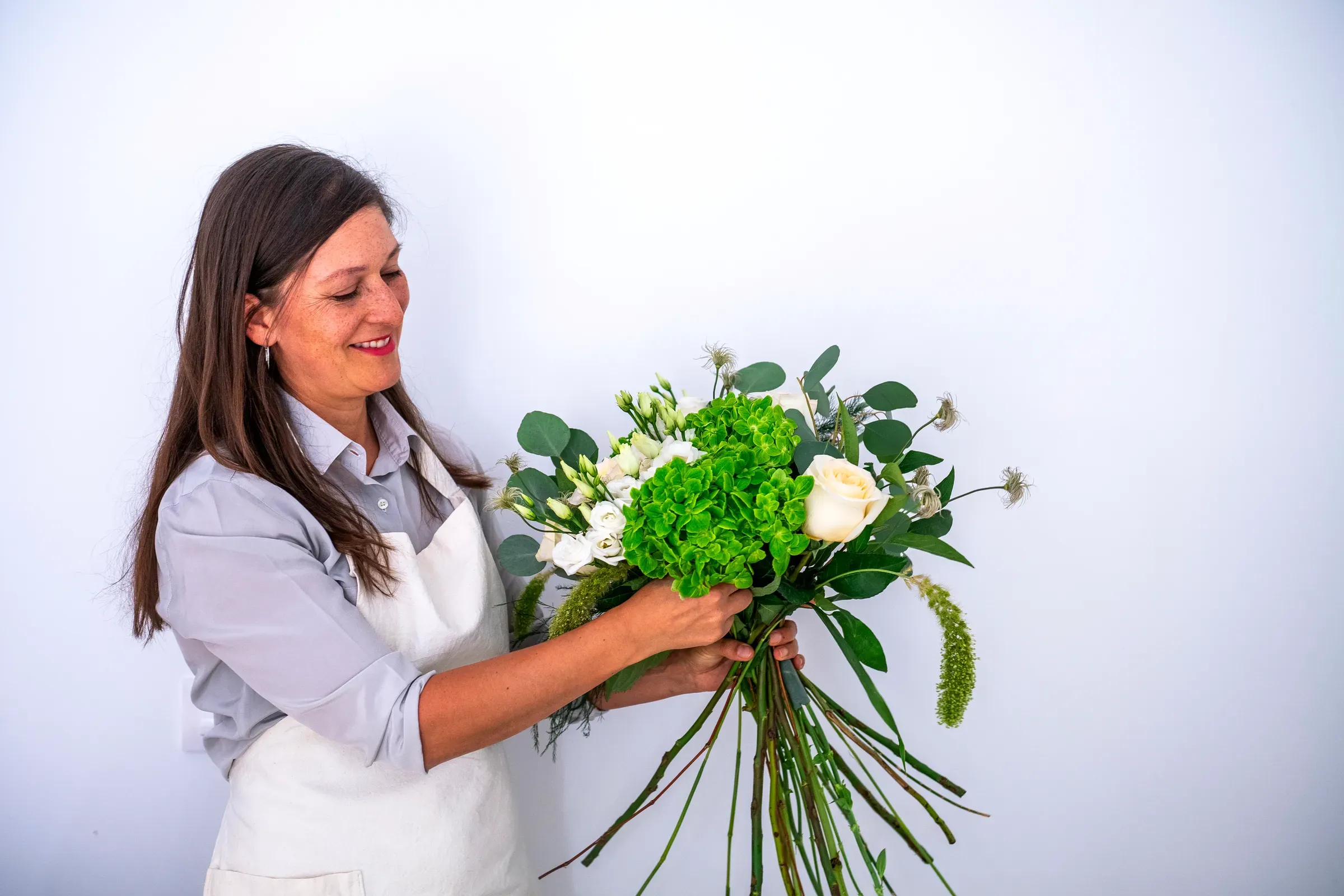 Florist arranging fresh flower bouquet for delivery, flower delivery ecommerce