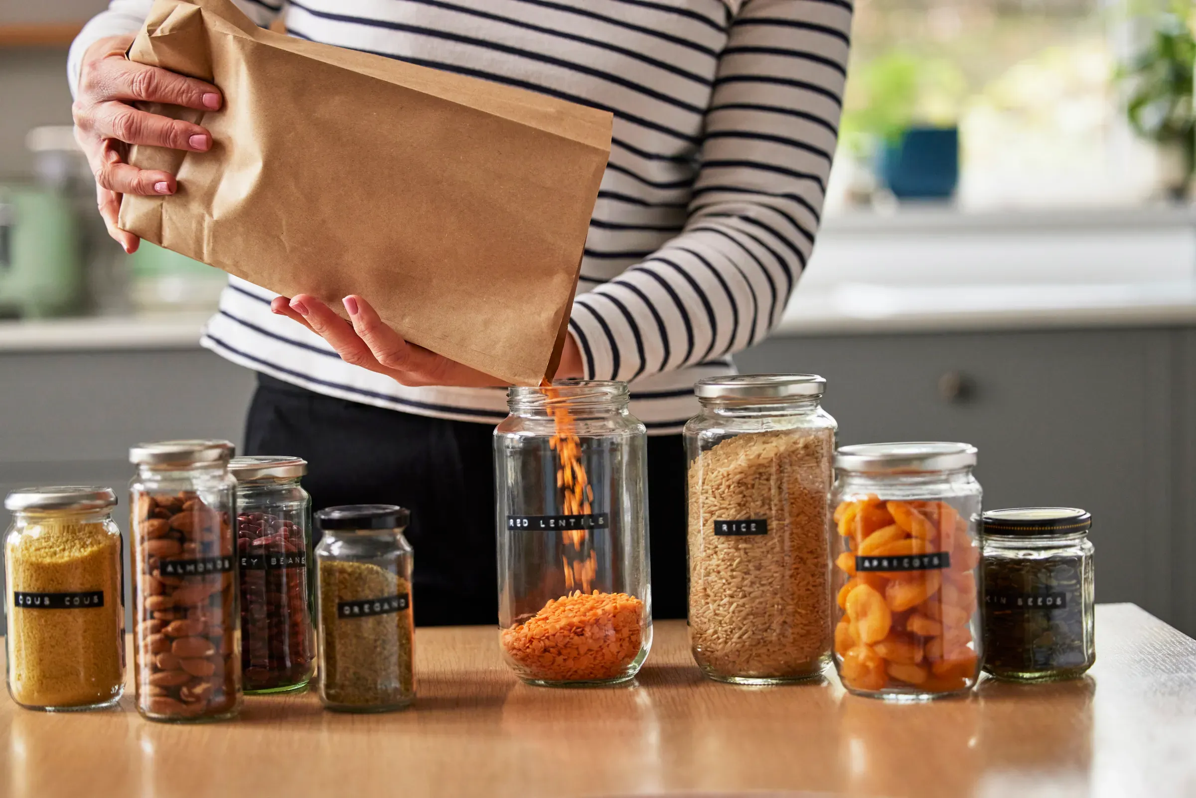 Woman Saving On Packaging By Filling Recycled Jars To Store Dried Food At Home, food & beverage ecommerce