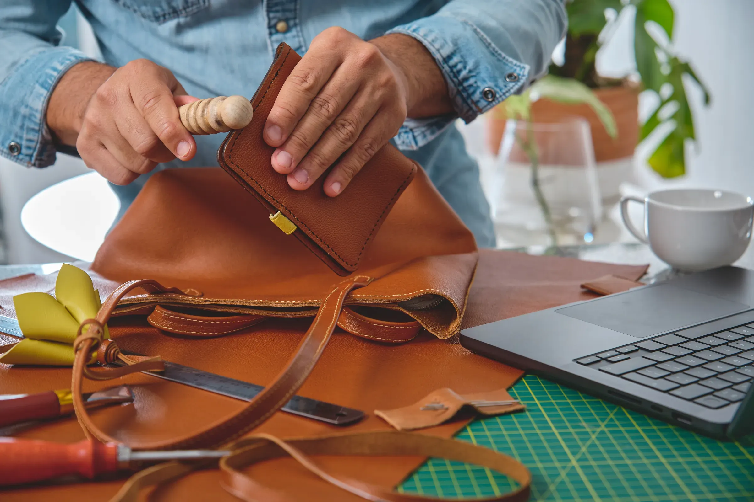 Leather craftsman working on handbag in workshop, handbags & leather goods ecommerce