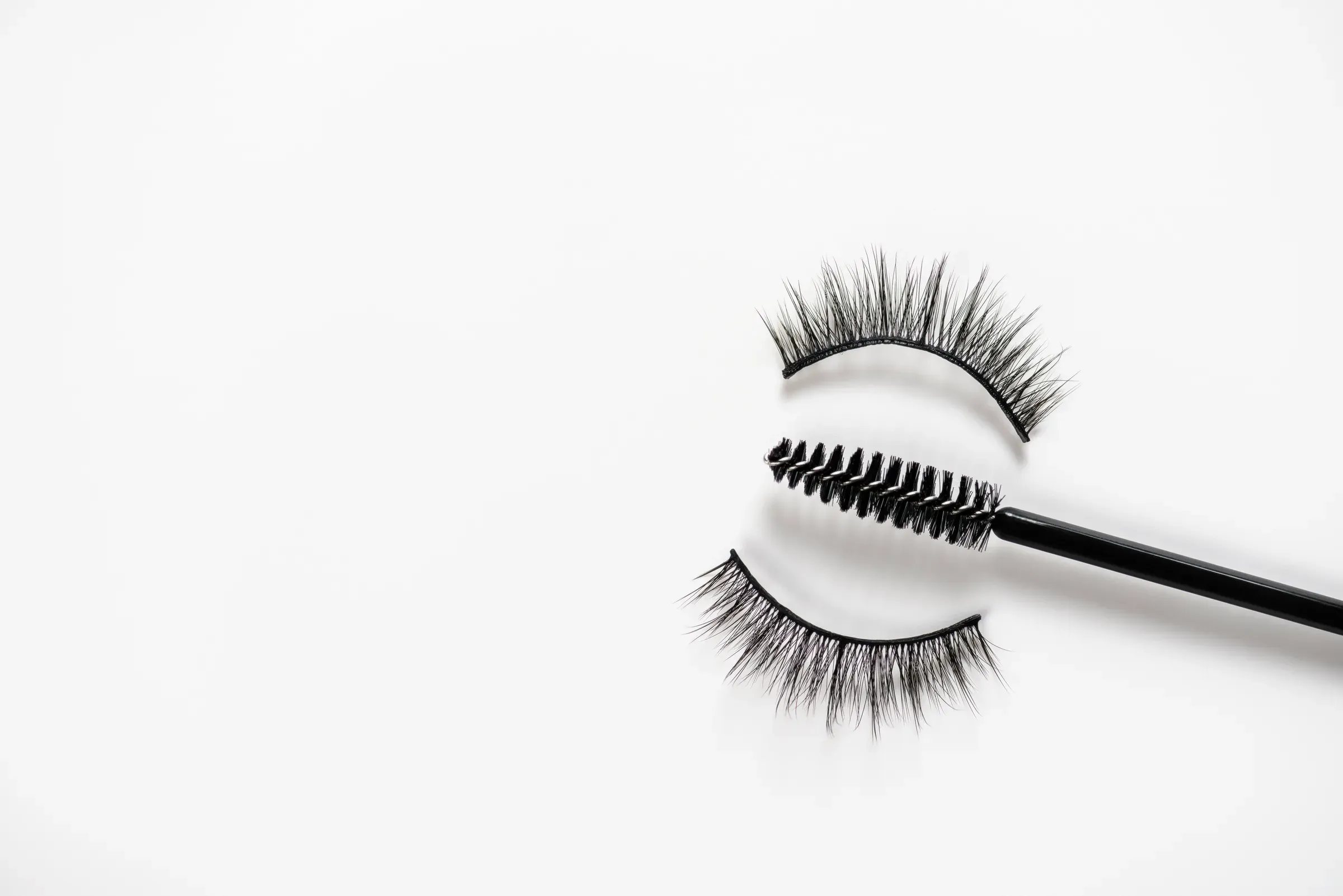 Short eyelash and eyebrow makeup brush with false eyelashes on white background. Women beauty and eye makeup, lash & brow products ecommerce