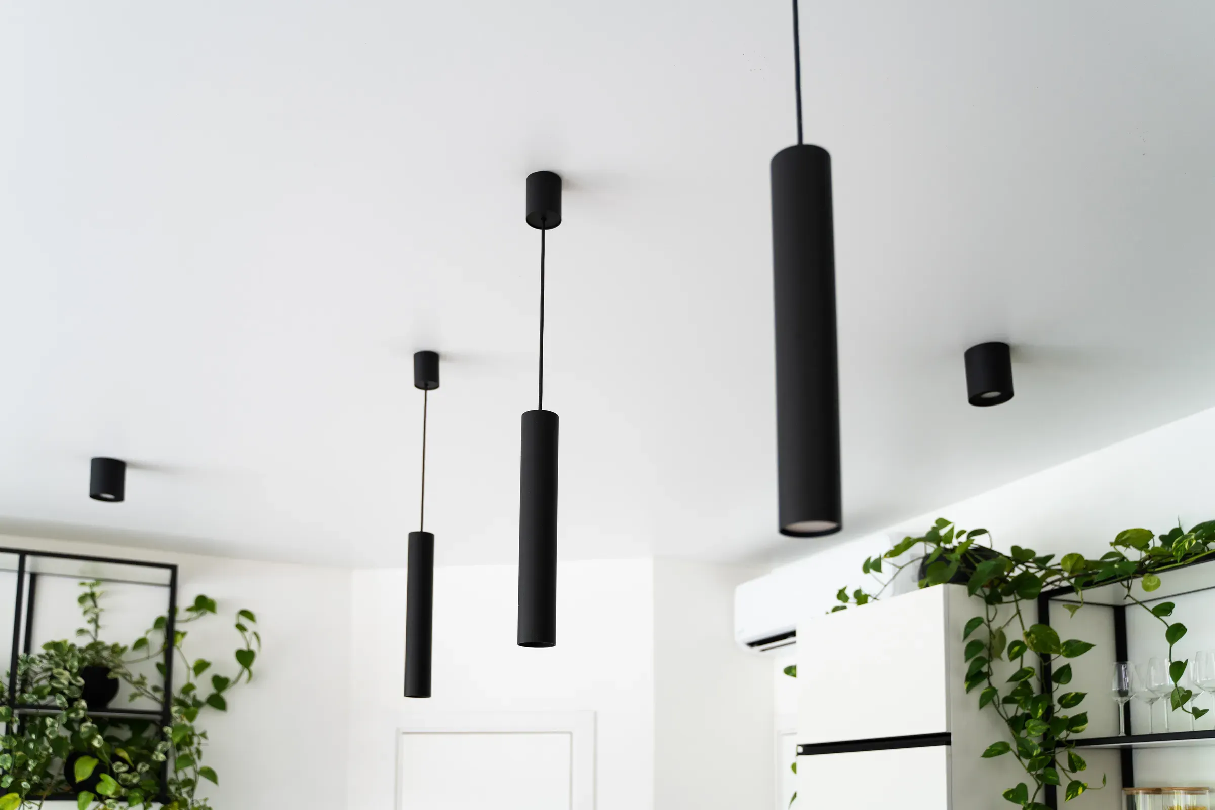 Contemporary interior with modern black pendant lamps on white ceiling, lighting ecommerce
