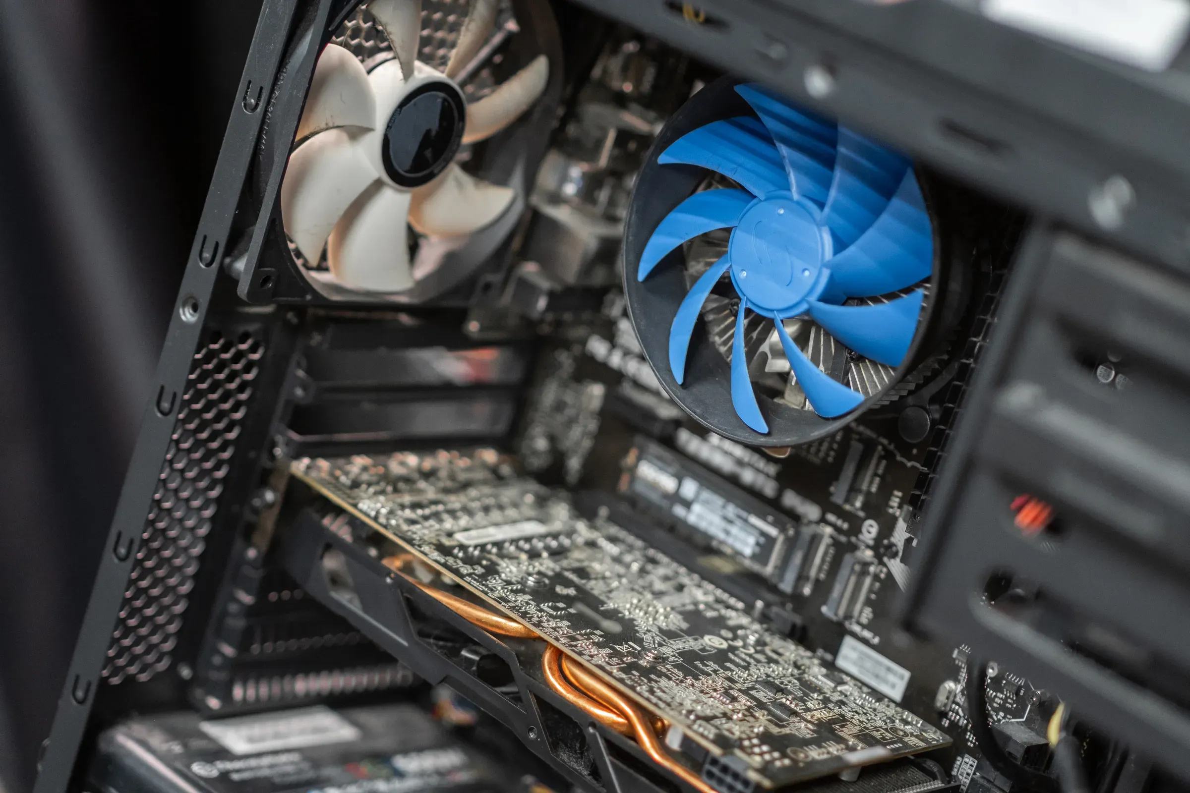 Inside a computer case showcasing components like a graphics card, cooling fan, and intricate circuitry, pc components & custom pcs ecommerce