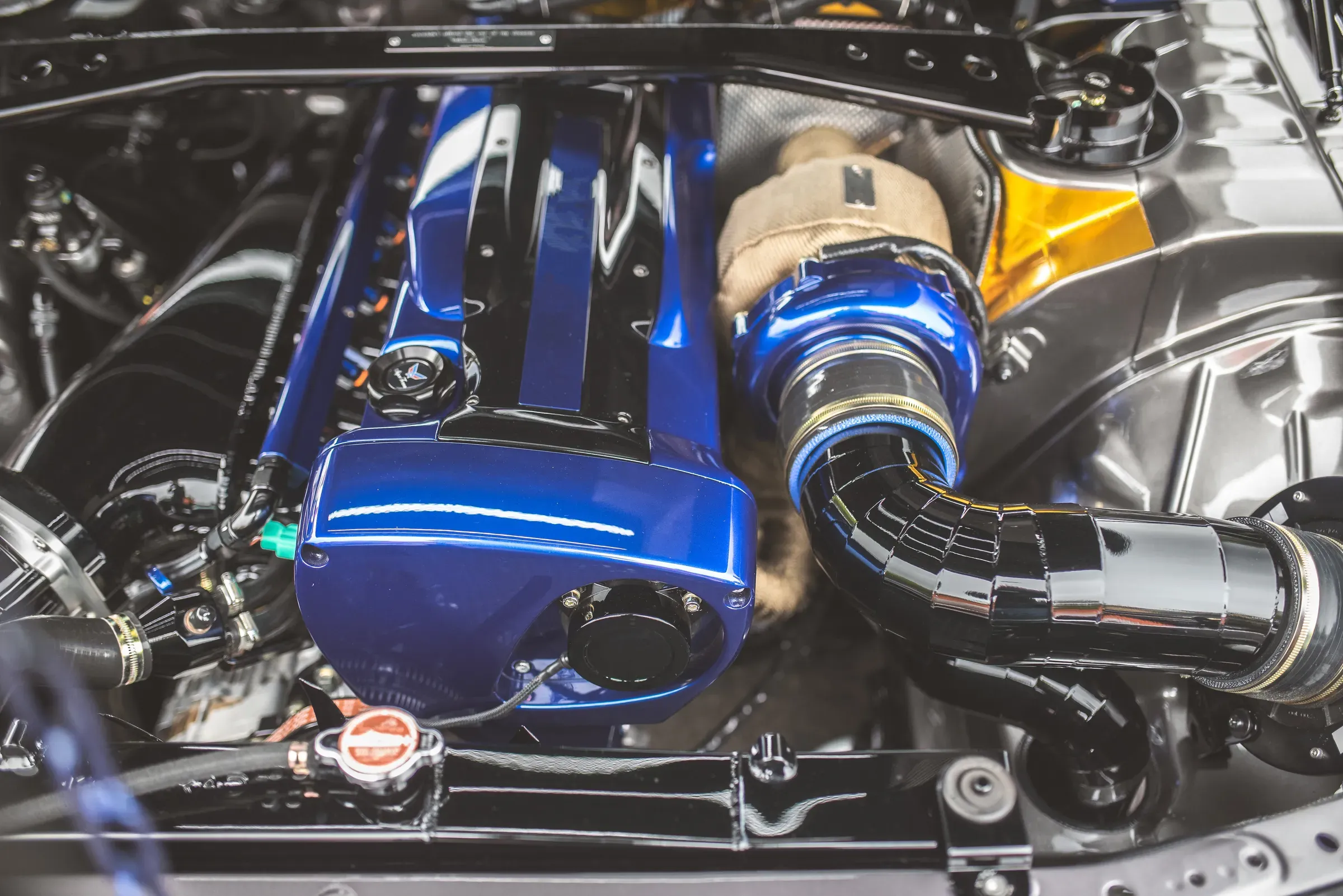 Close-up view of a polished blue performance car engine with turbocharger, performance & tuning parts ecommerce