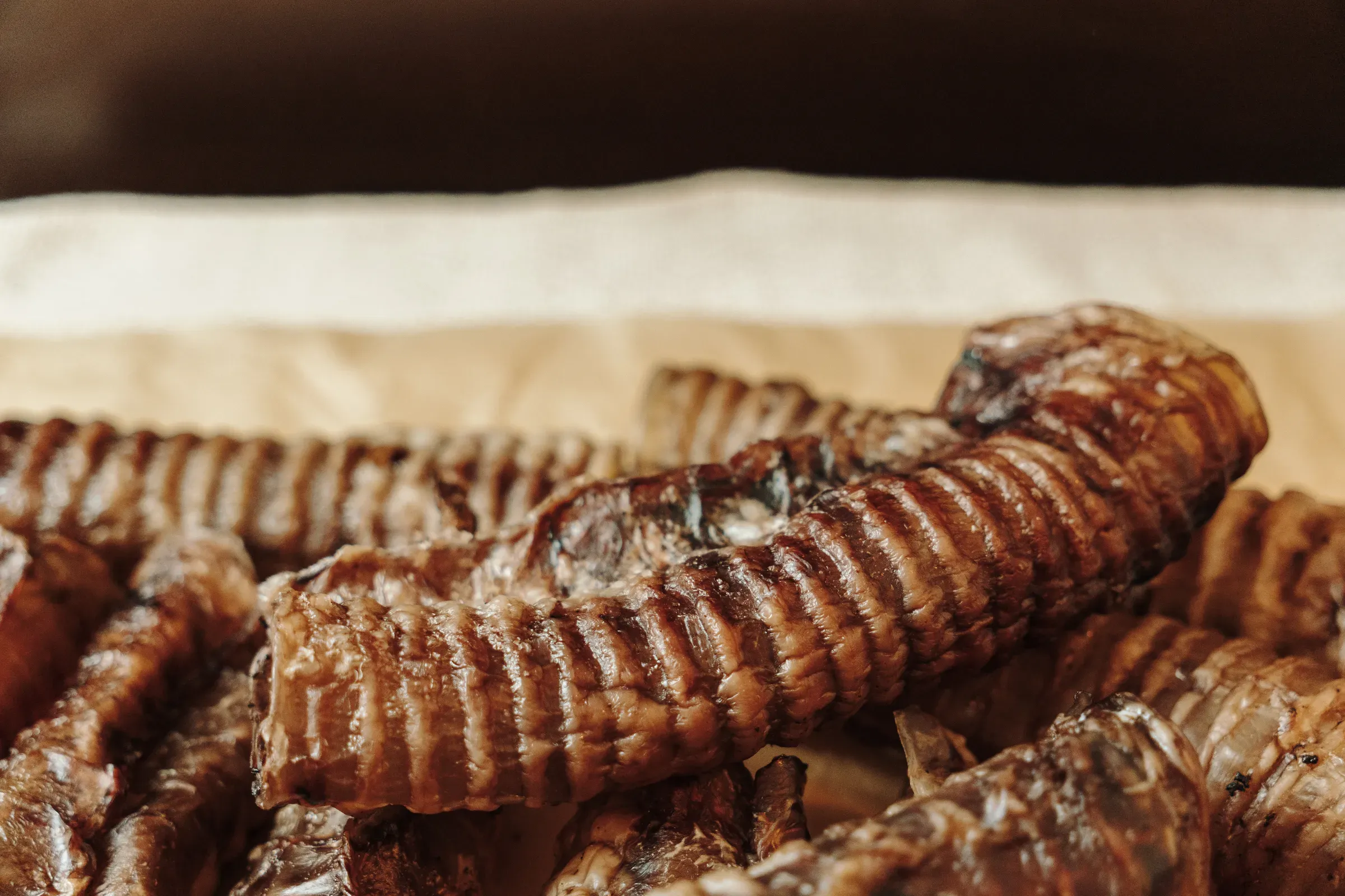 Pile of dried beef trachea chews on kraft paper. Natural collagen rich dog treats made from a single, pet treats & chews ecommerce