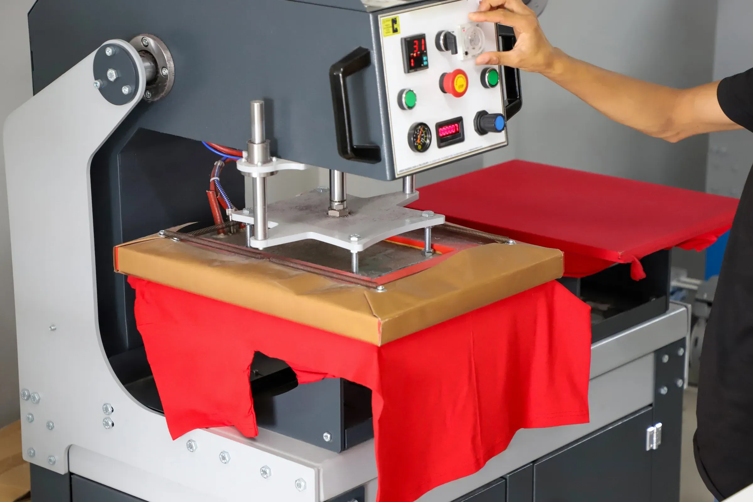 Press printing on colored t-shirts, press for printing images on fabric. Large industrial textile printing, print-on-demand ecommerce
