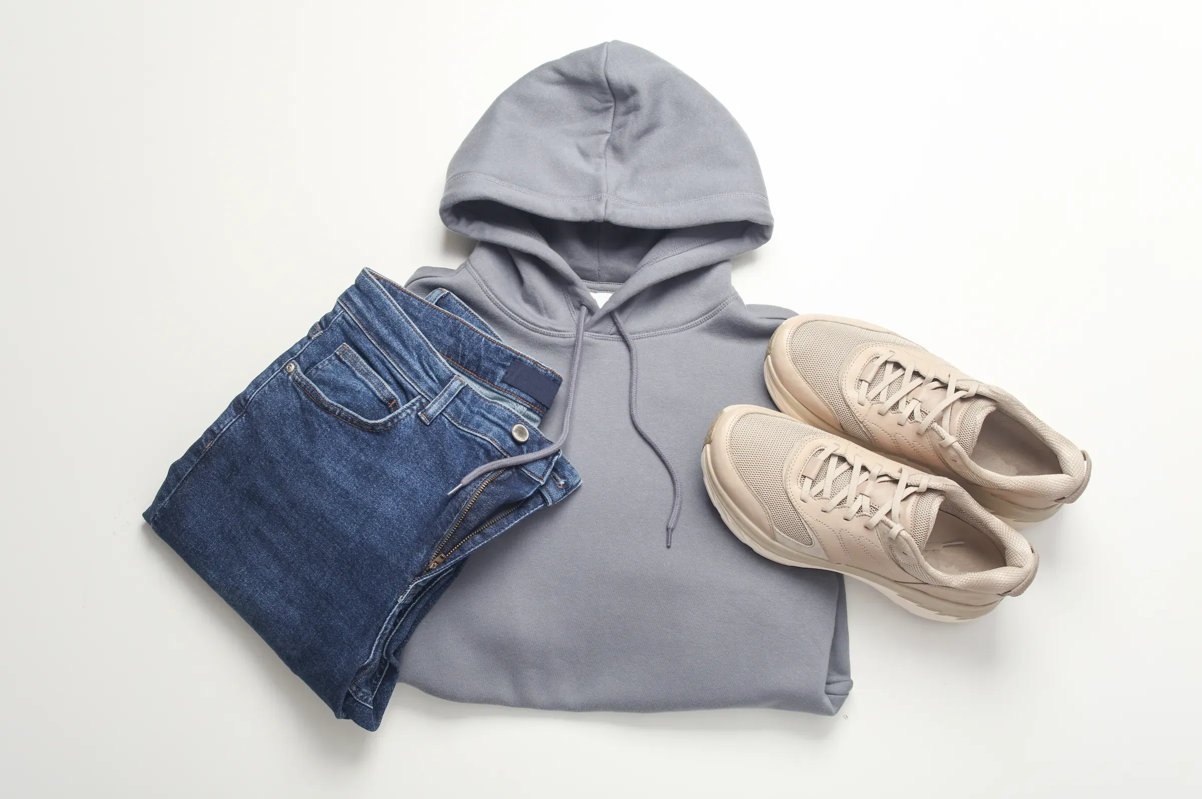Men's youth clothing style. Jeans, sneakers and hoodie on a white background. Flat lay. Top view, streetwear ecommerce