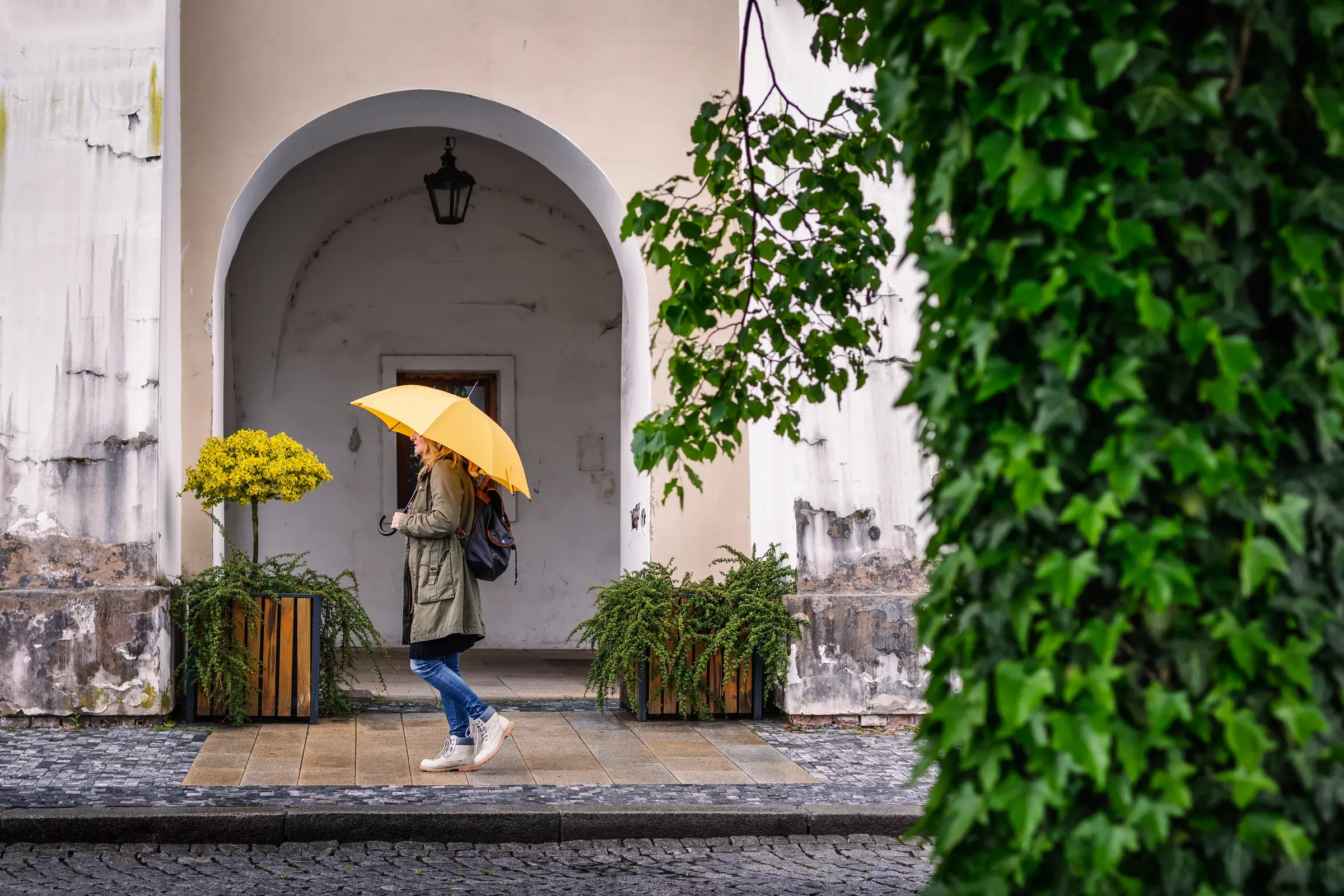 Woman with yellow umbrella walking at city street in rain, umbrellas & rain gear ecommerce